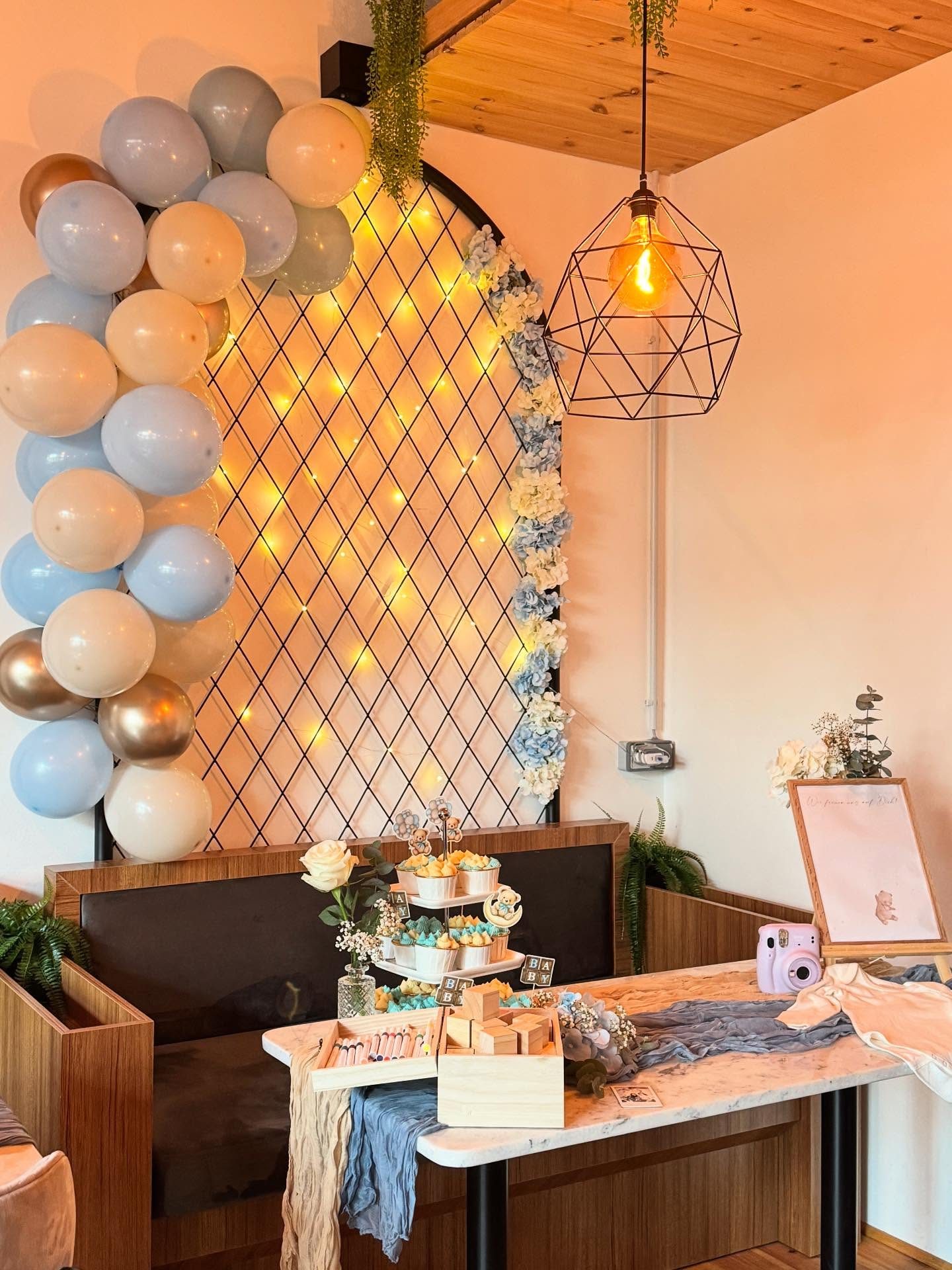 Ballonbogen und Blumendeko für eine Feier im Café