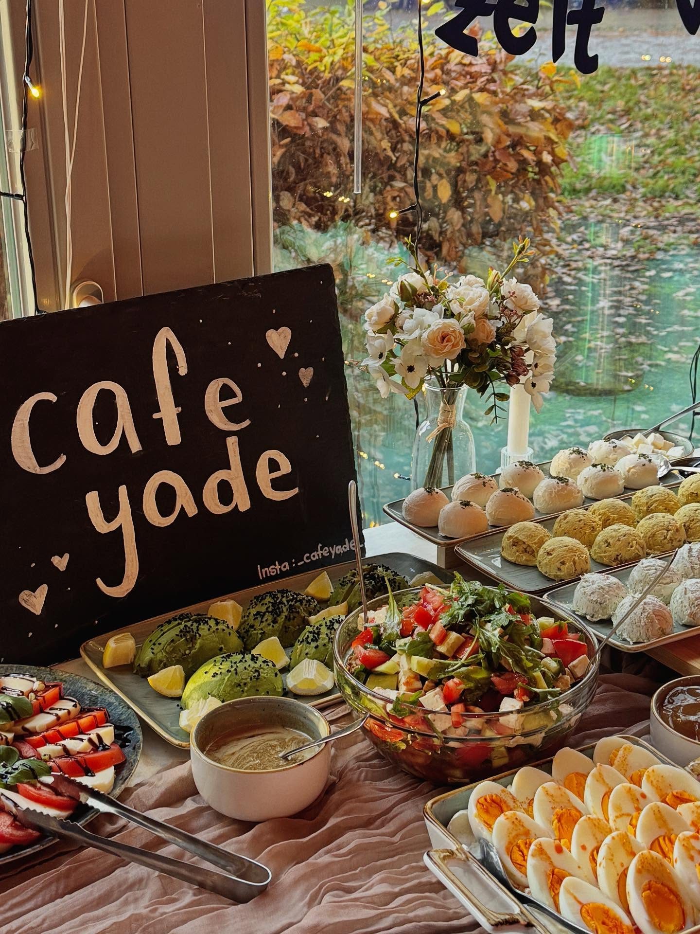 Kreidetafel mit Café-Yade-Schriftzug vor dem Buffet